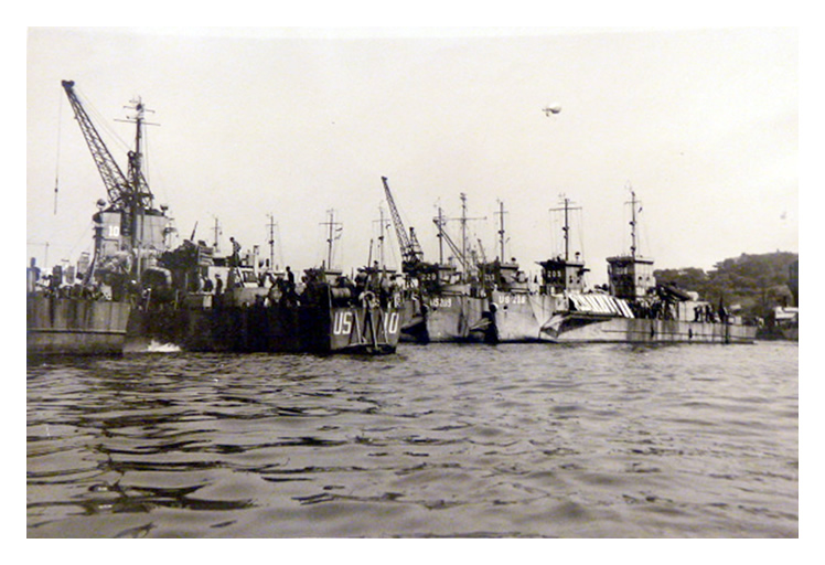 1943-4 - A view of the stern of LST US-10 with the bows of US-218 and US-209 visible.