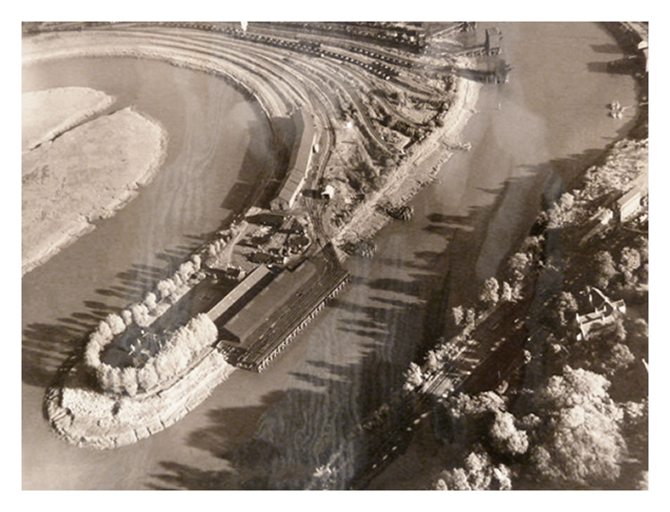 1955 - An aerial view of the meandering River Ely with the Victoria Wharf of the South Wales Warehouses Limited and associated warehouse and rail facilities. 