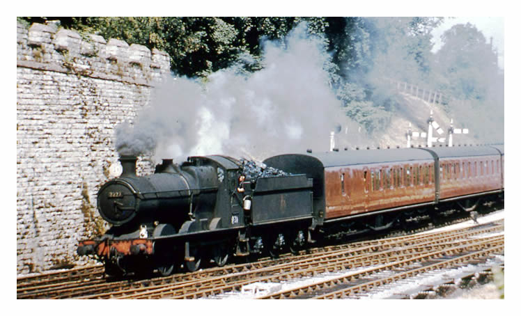 A pasenger train passing Cogan Junction, pulled by a 7200 Class, Number 7227 engine.