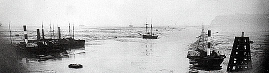 A mid-1860's view of the narrow channel at low water between the entrance of the Bute Docks and the Seven Sea with Penarth Head distant.