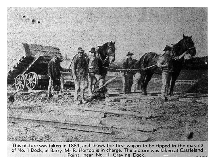 A black and white photograph of the first wagon to be tipped in the construction of No.1 Dock at Barry in 1884. Mr. Hortop is in charge. The picture was taken at Castleland Point, near No.1 Graving Dock.